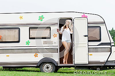 Young and beautiful hippy girl standing in trailerâ€™s door. Stock Photo